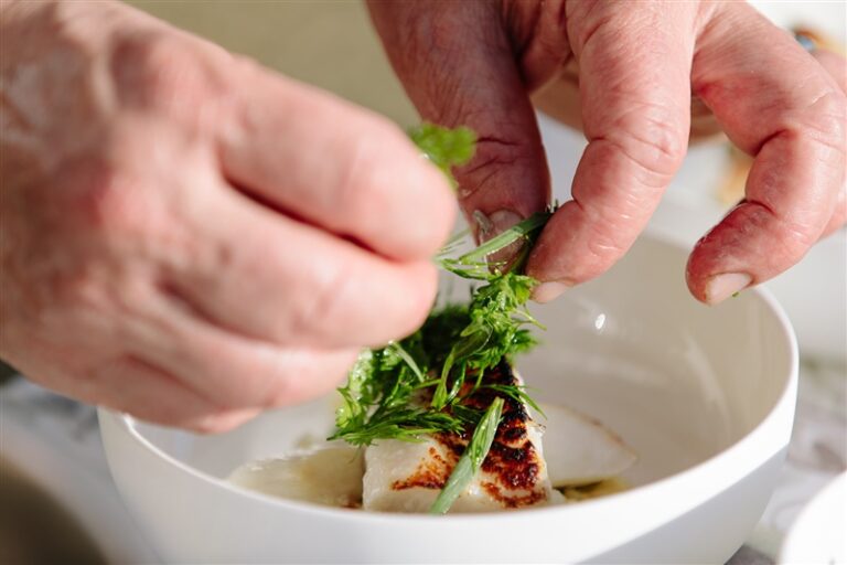 chef adding garnish to a dish