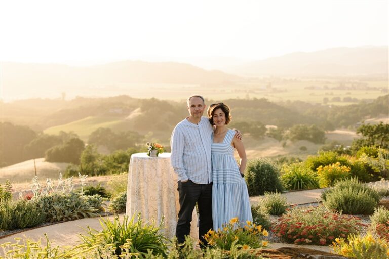 couple posing by high-top table in front panromantic vista view
