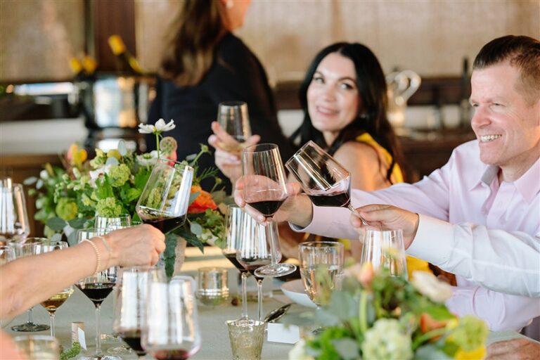 group toasting with glasses of cabernet sauvignon at elegant dinner table