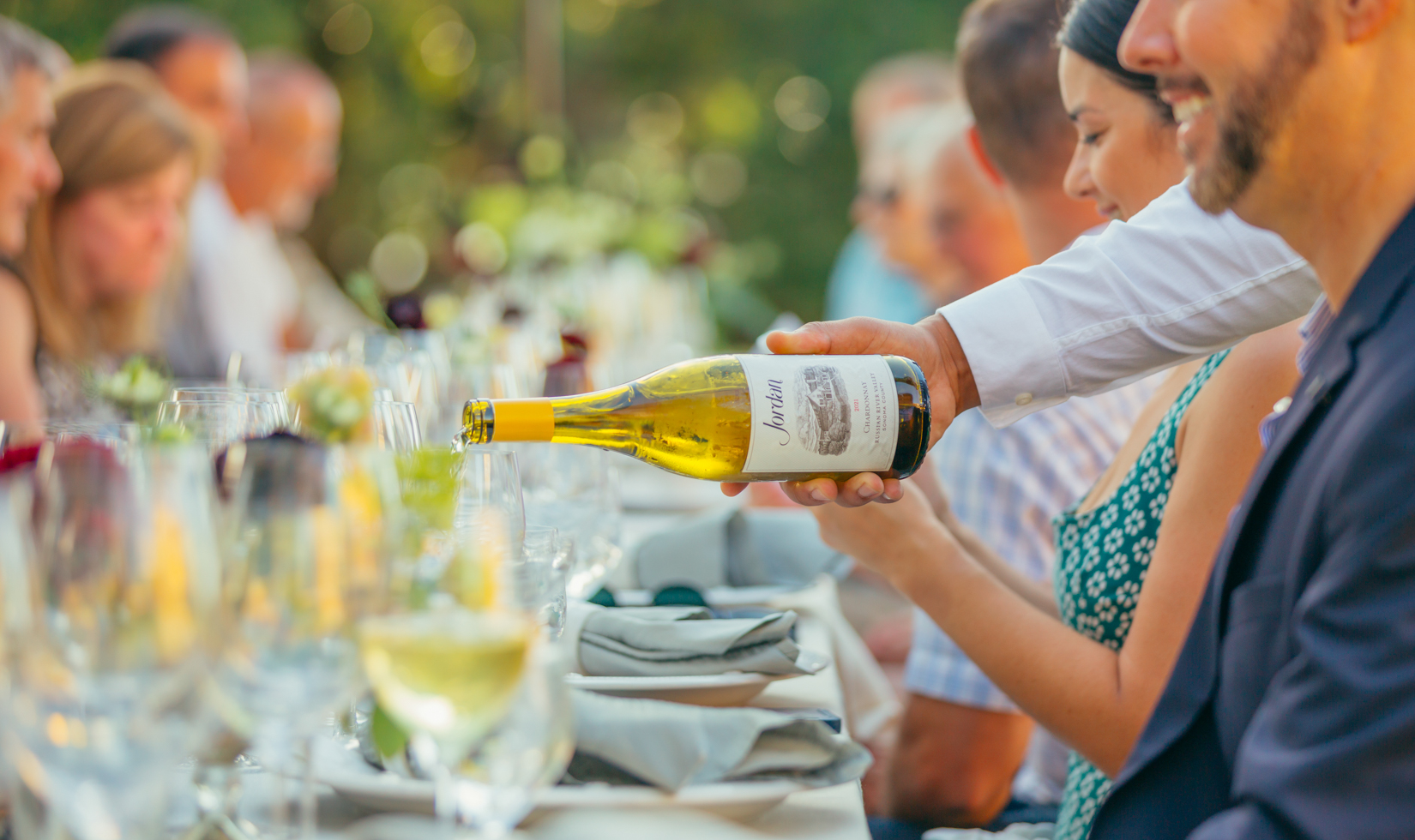 wine server pouring glass of jordan chardonnay for guest