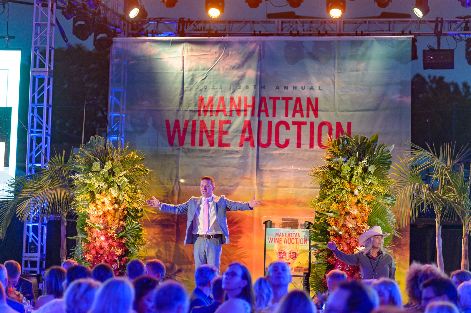 auctioneer on main stage of manhattan beach wine auction at night