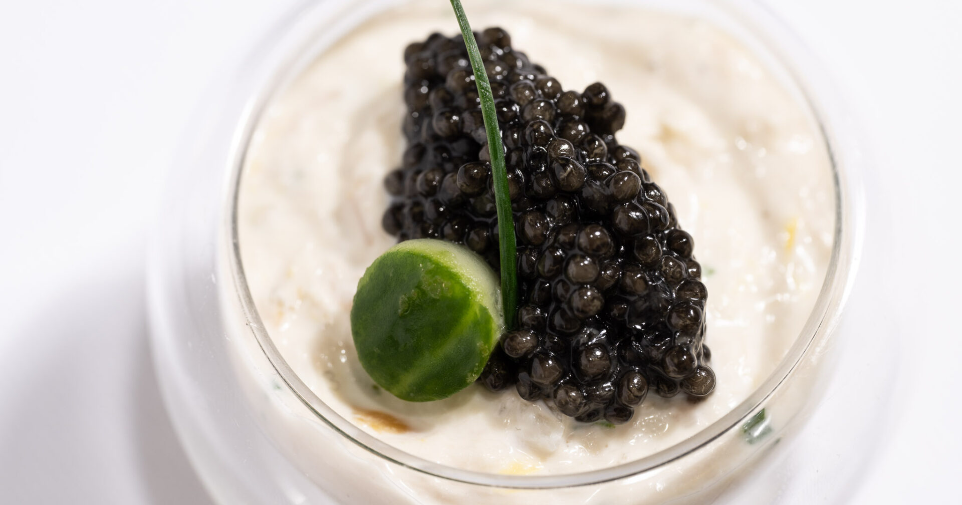 Smoked Sturgeon and Caviar with Cucumbers and Chives in a small glass dish