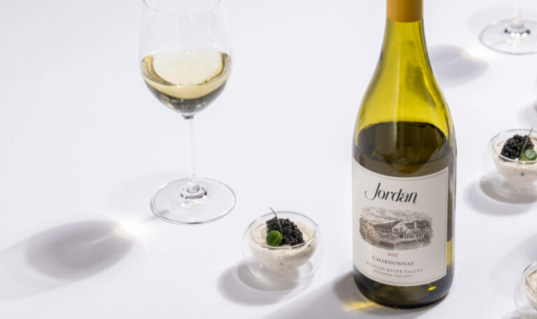 bottle of jordan chardonnay on white with glass dishes hors d'oeuvre arranged around the bottle