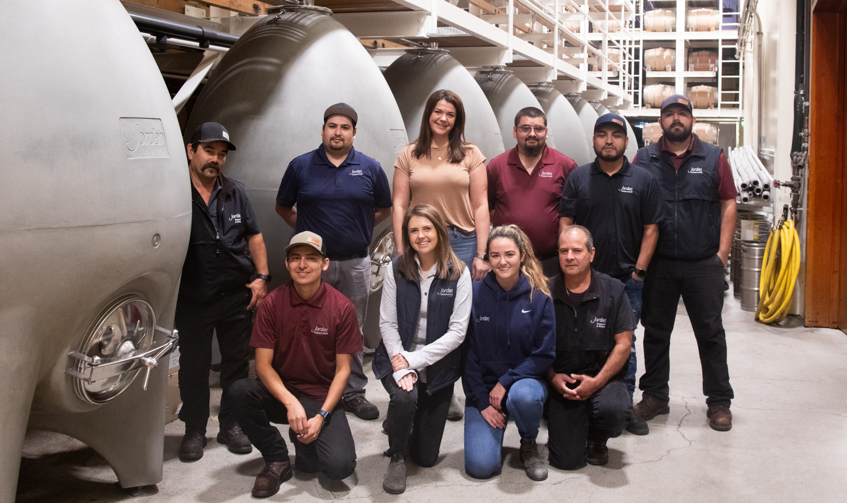 winemaking cellar team in front of concrete eggs in barrel room