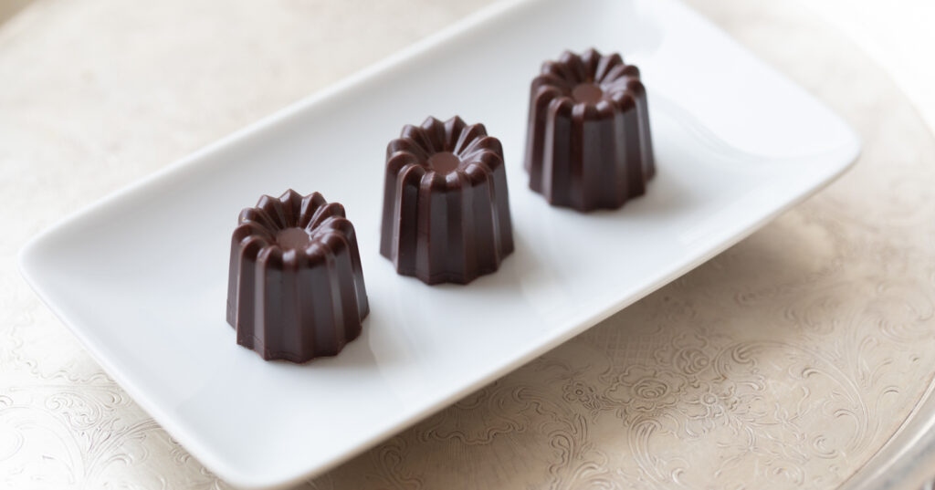 three chocolate truffles on white plate